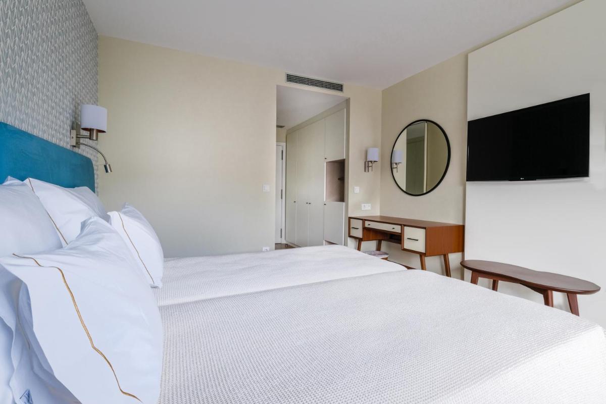 Uma cama ou camas num quarto em Hotel Vouga