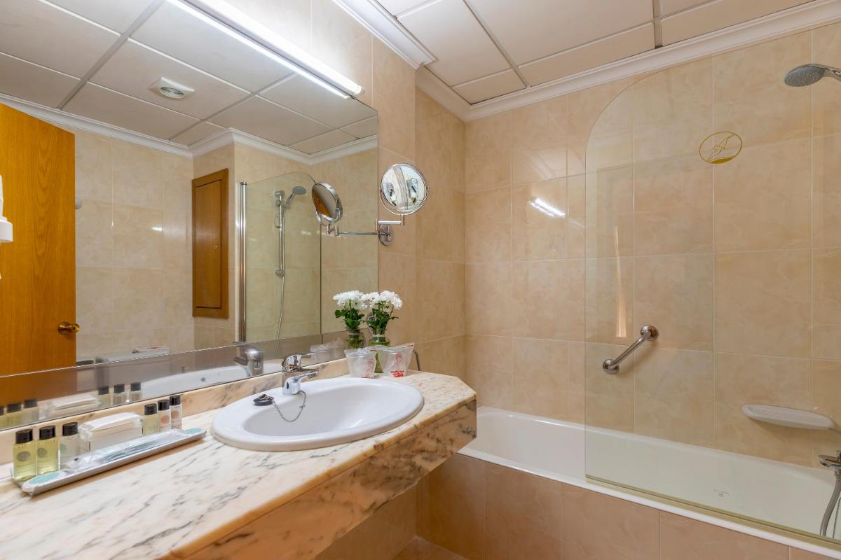 un baño con lavabo y ducha en Hotel Miramar Mallorca, en Puerto Pollensa