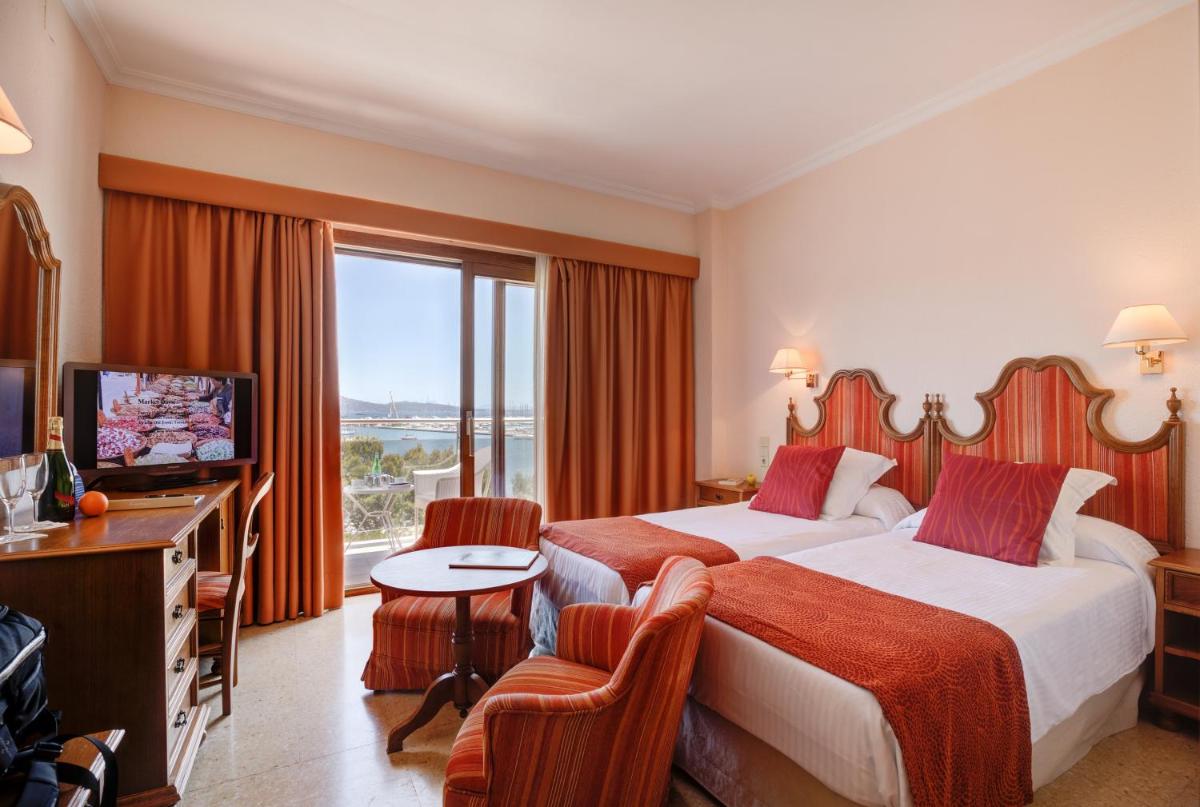 Una habitación de hotel con dos camas y un televisor. en Hotel Miramar Mallorca, en Puerto Pollensa