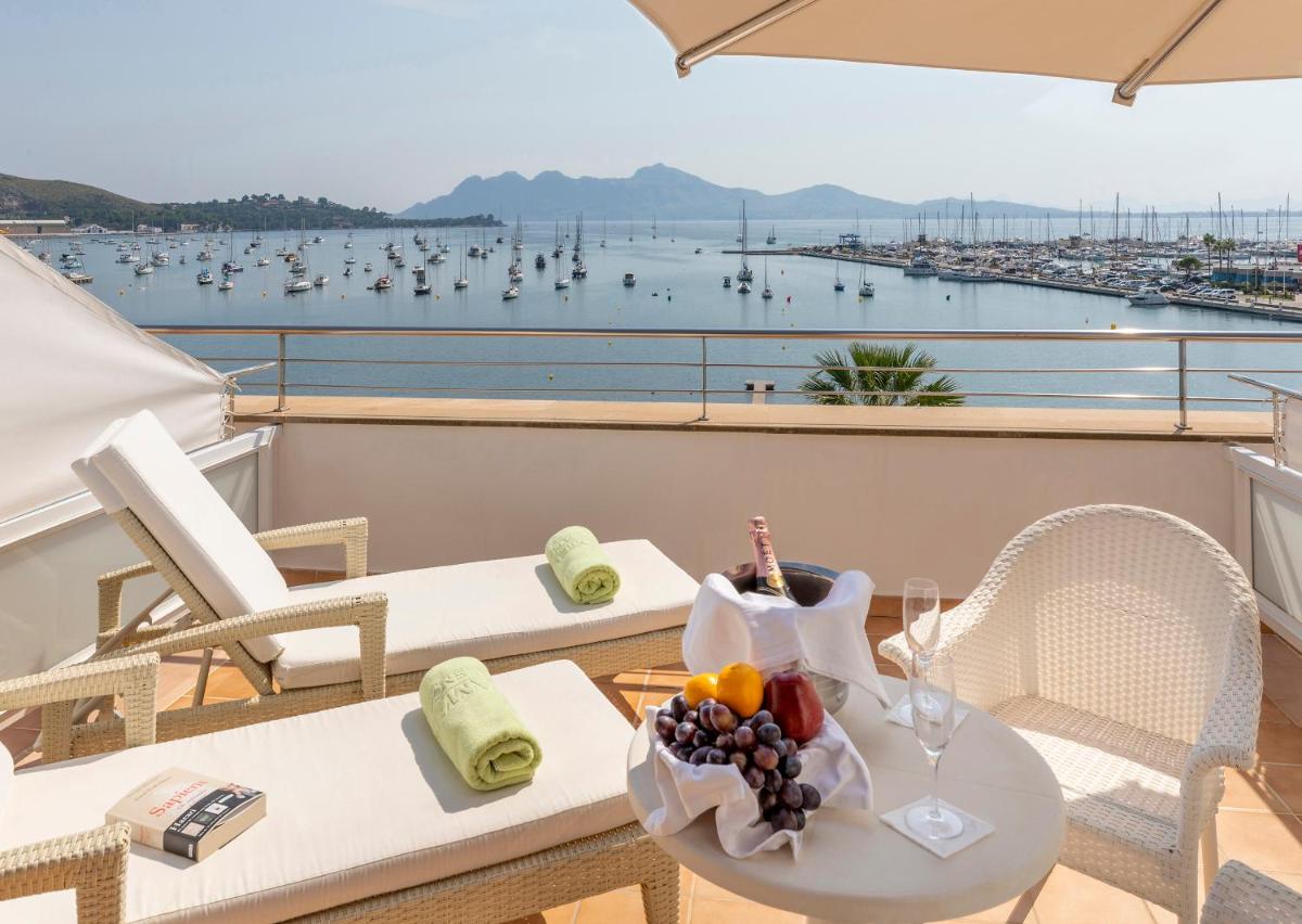 Una mesa con un bol de fruta en un balcón. en Hotel Miramar Mallorca, en Puerto Pollensa
