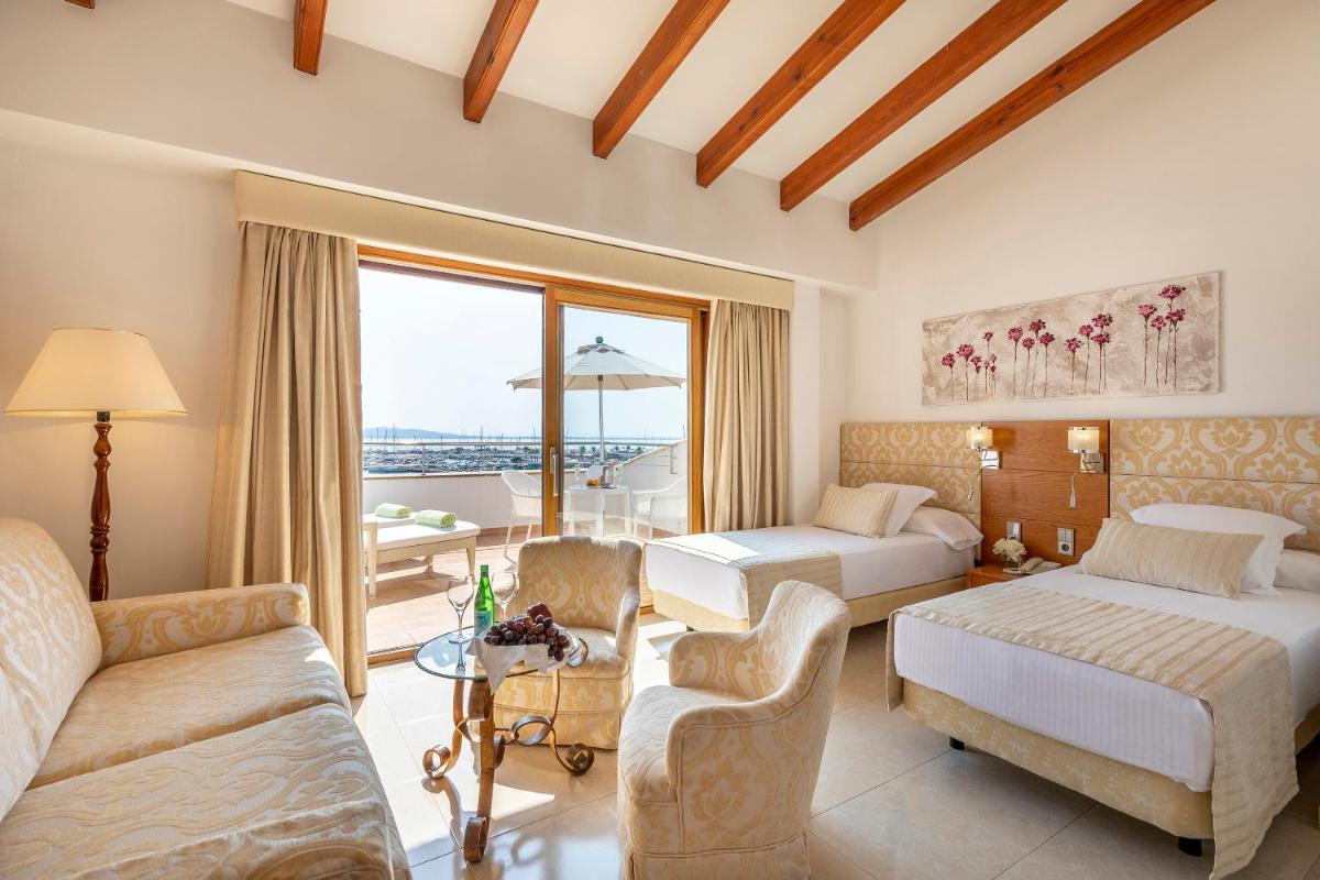 Una habitación de hotel con dos camas y una sala de estar. en Hotel Miramar Mallorca, en Puerto Pollensa