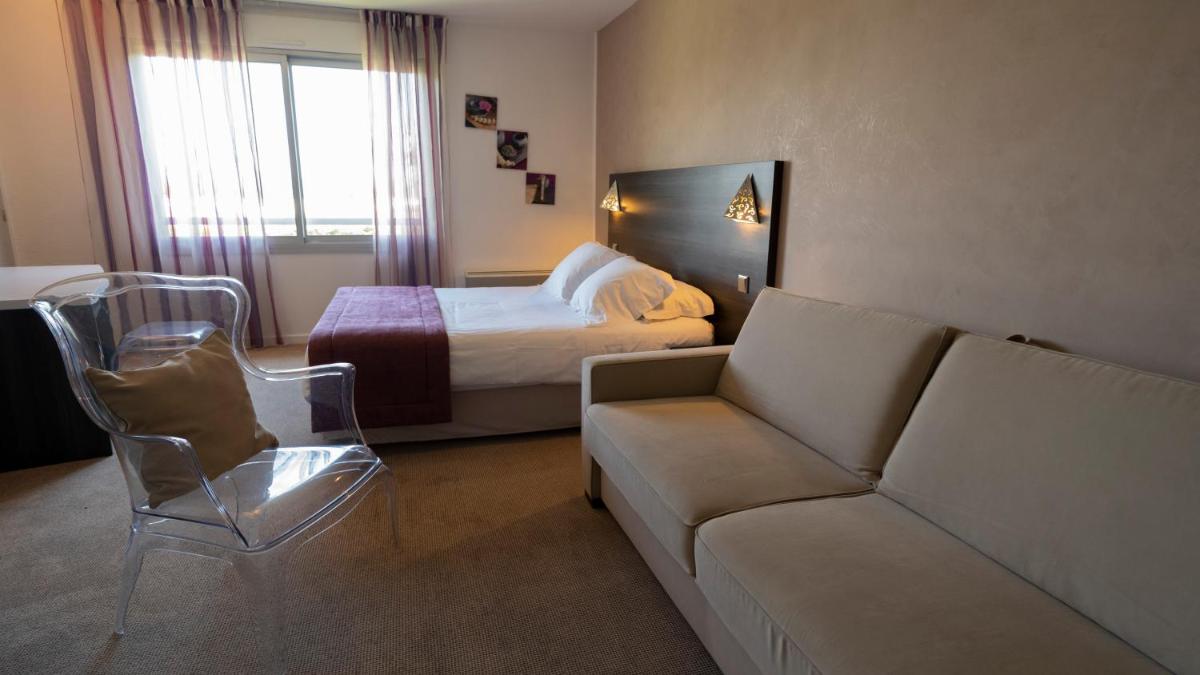 Coin salon dans l'établissement Logis Hotel Restaurant SPA Les Oliviers