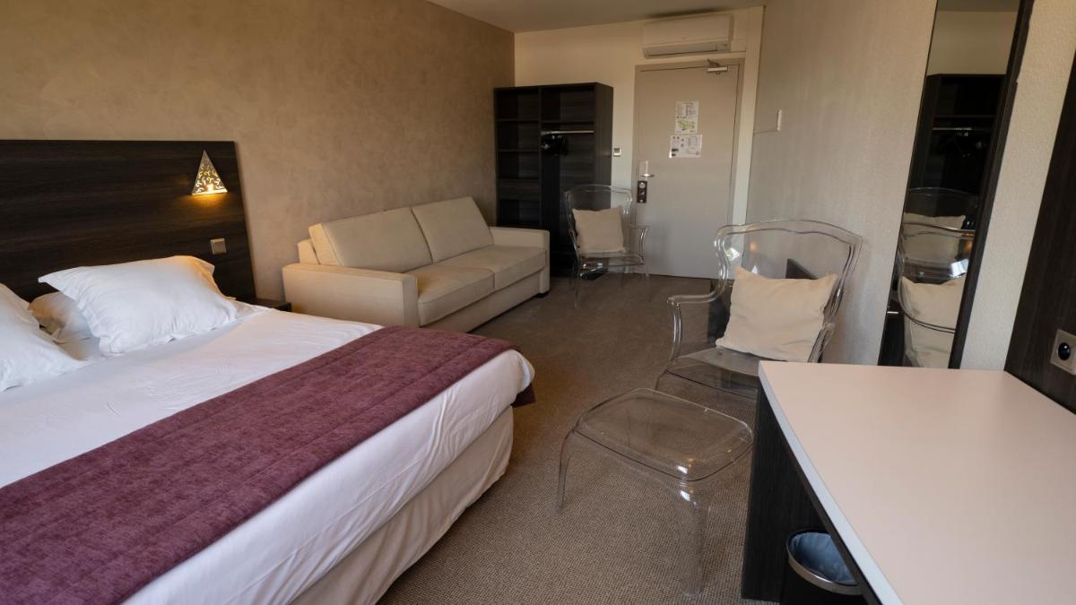 Un ou plusieurs lits dans un hébergement de l'établissement Logis Hotel Restaurant SPA Les Oliviers