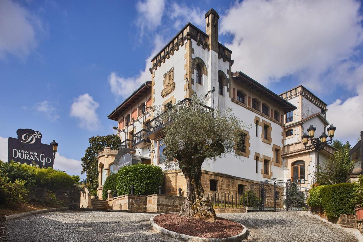 un edificio con un árbol delante en Silken Gran hotel Durango, en Durango