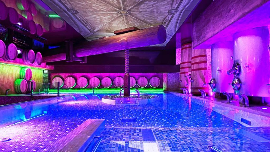 una piscina con iluminación púrpura y verde en Hotel SPA El Lagar de Isilla, en La Vid y Barrios