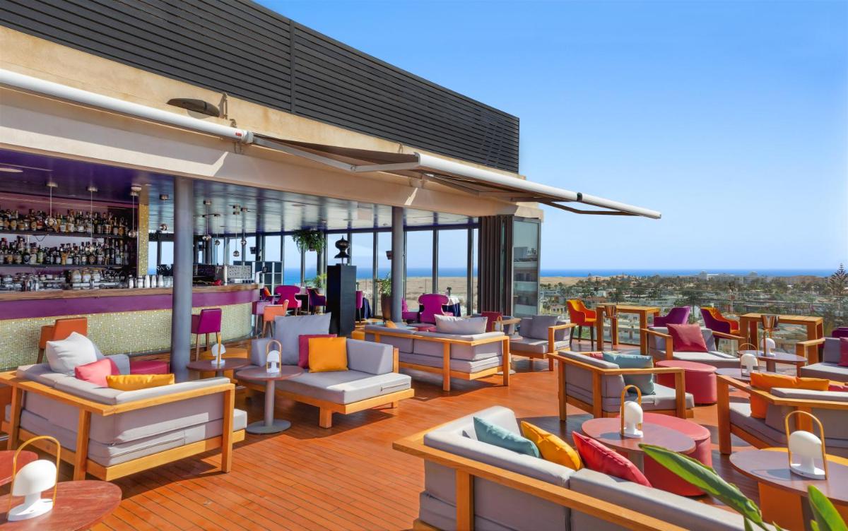 un restaurante con sofás y un bar en Bohemia Suites & Spa - Adults Only, en Playa del Inglés