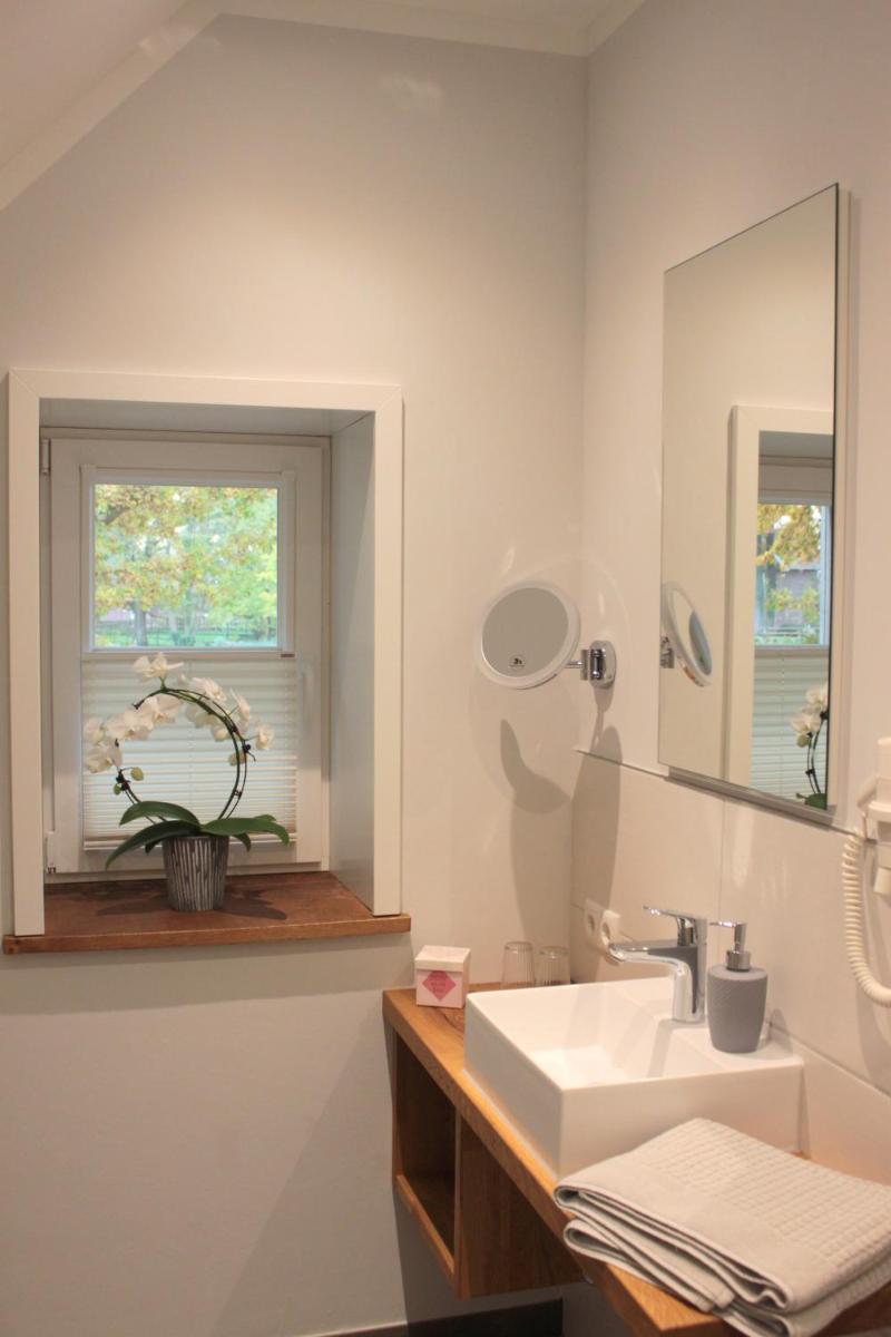 ein Badezimmer mit Waschbecken und Fenster in der Unterkunft DZ/EZ Lodberger Scheunencafe in Löningen