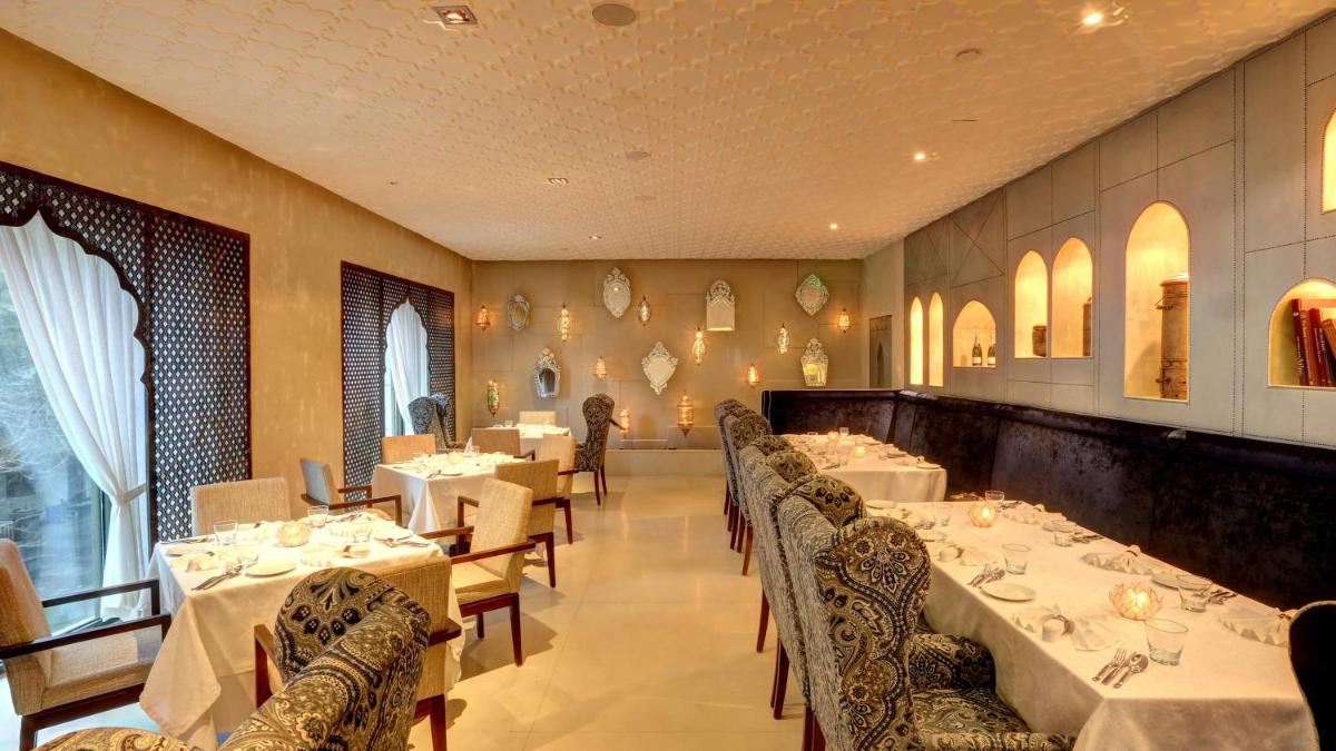 a restaurant with tables and chairs with white tablecloths at InterContinental Marine Drive Mumbai by IHG in Mumbai