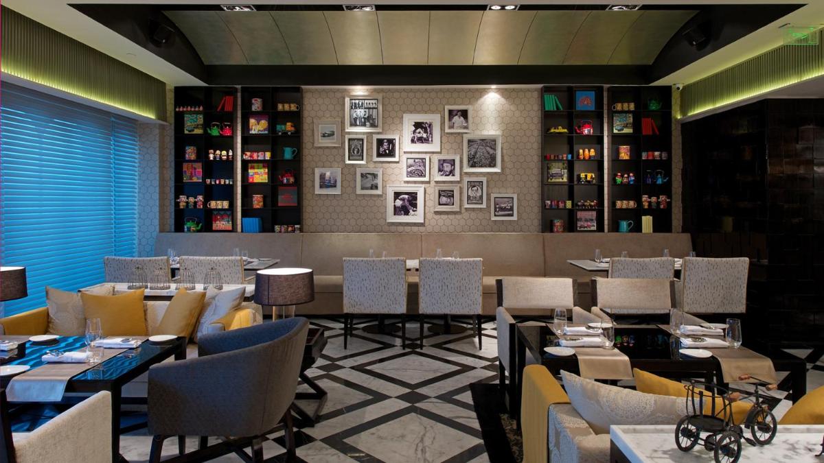 a restaurant with tables and chairs and pictures on the wall at InterContinental Marine Drive Mumbai by IHG in Mumbai