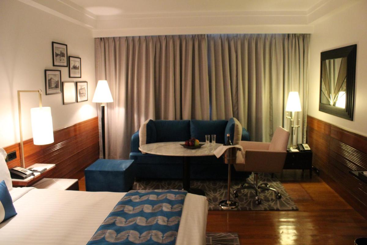 a hotel room with a bed and a couch and a table at InterContinental Marine Drive Mumbai by IHG in Mumbai