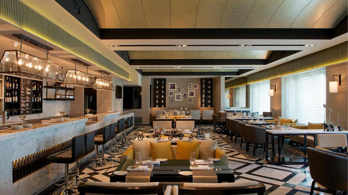 a restaurant with tables and chairs and a bar at InterContinental Marine Drive Mumbai by IHG in Mumbai