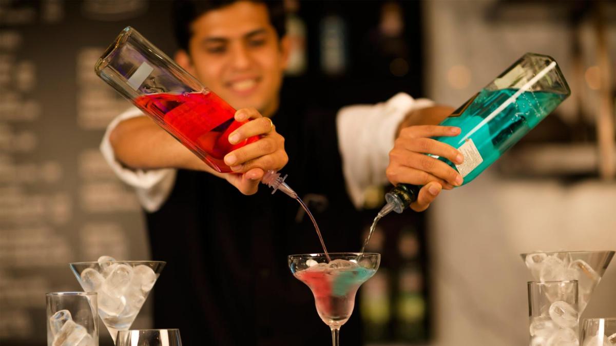 a man pouring a drink into a martini glass at InterContinental Marine Drive Mumbai by IHG in Mumbai