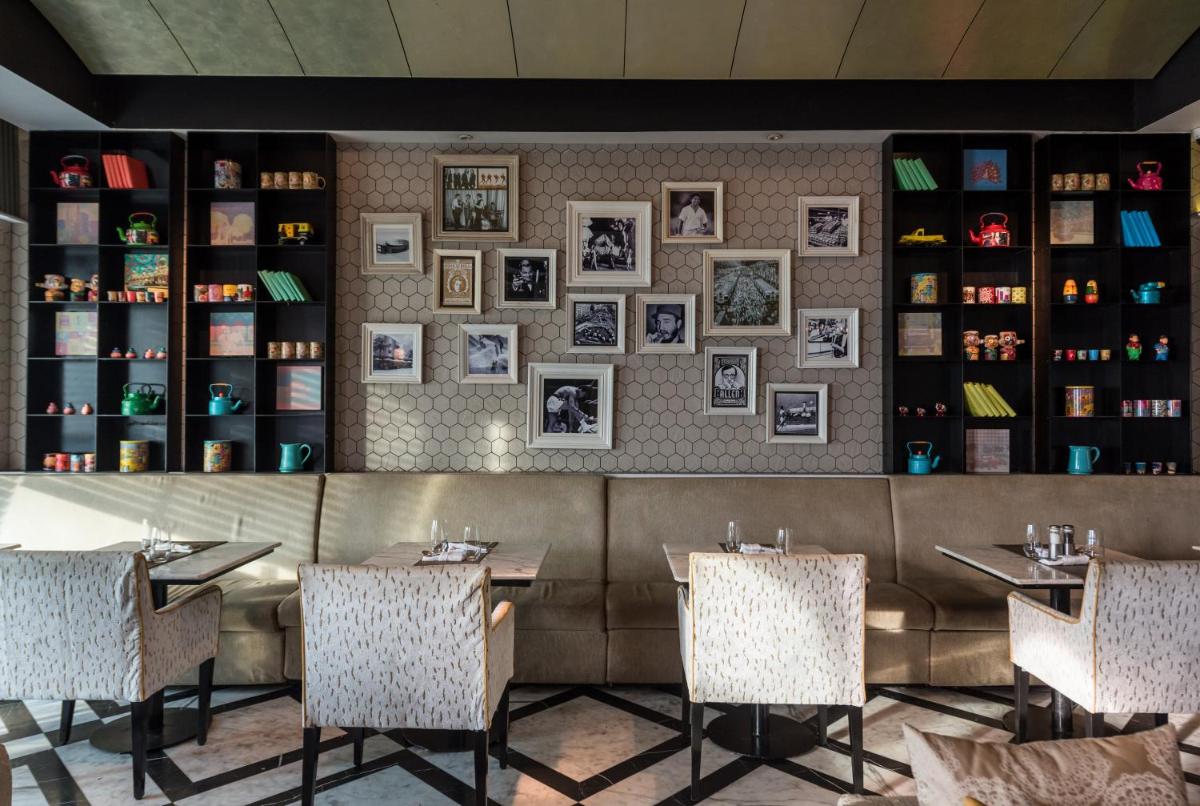 a restaurant with tables and chairs and pictures on the wall at InterContinental Marine Drive Mumbai by IHG in Mumbai
