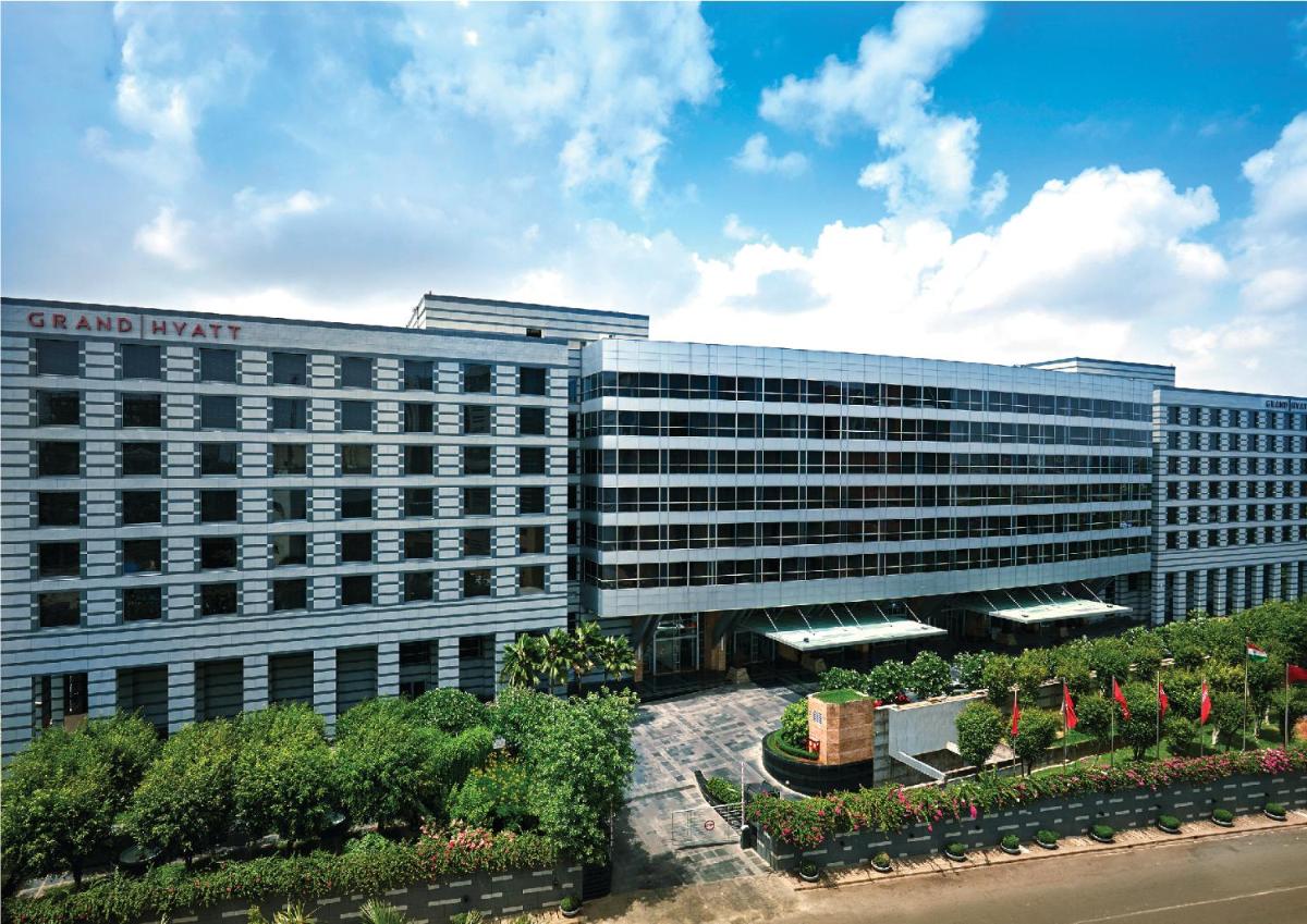 a large building with a sign on the side of it at Grand Hyatt Mumbai Hotel and Residences in Mumbai