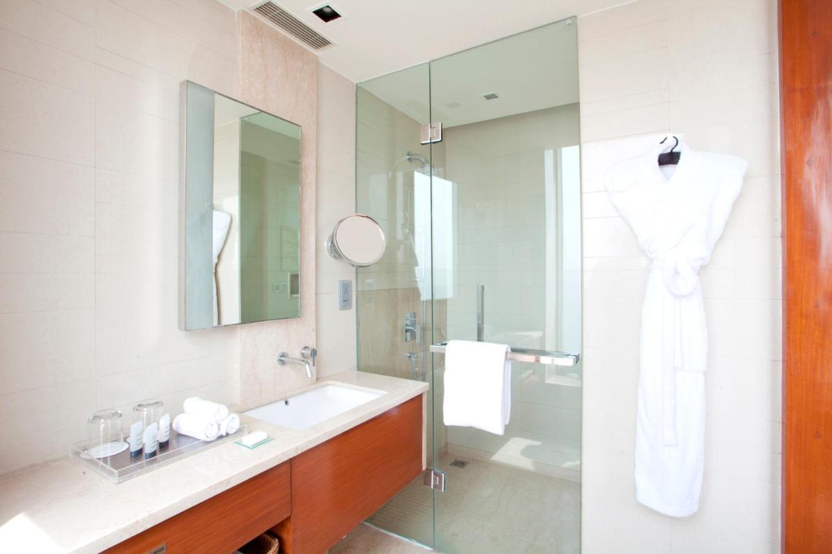 a bathroom with a sink and a shower with a mirror at Hyatt Regency Amritsar Hotel & Spa in Amritsar