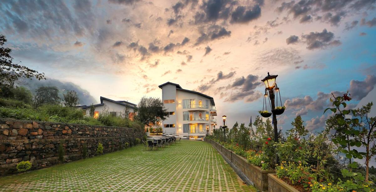 a large white building with a cloudy sky in the background at Welcomhotel by ITC Hotels, Shimla in Shimla