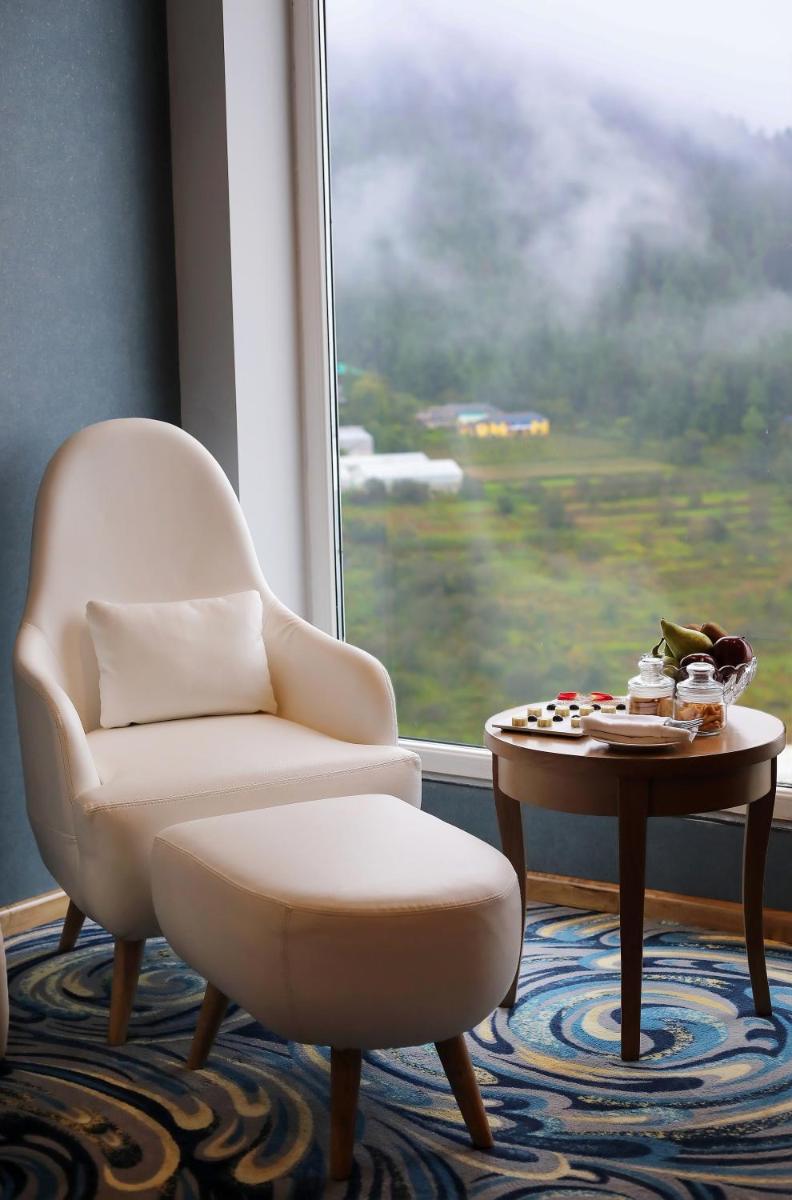 a room with a chair and a table and a window at Welcomhotel by ITC Hotels, Shimla in Shimla