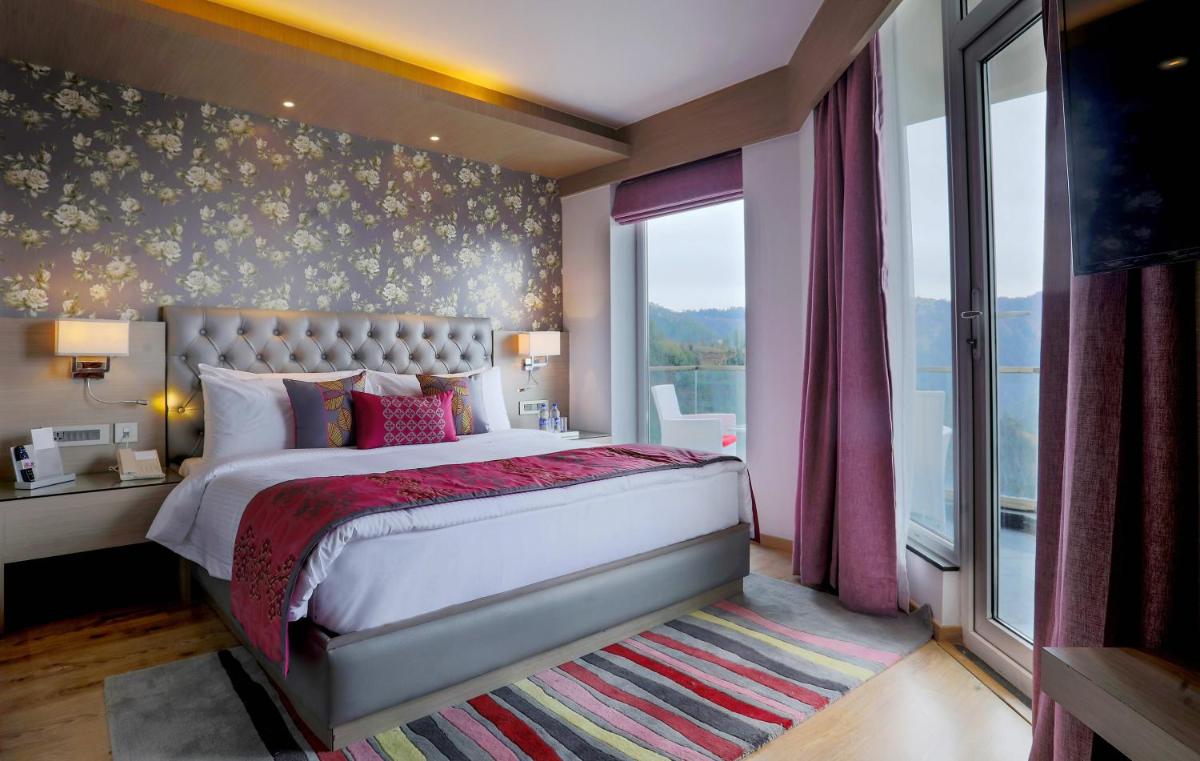 a bedroom with a large bed and a large window at Welcomhotel by ITC Hotels, Shimla in Shimla