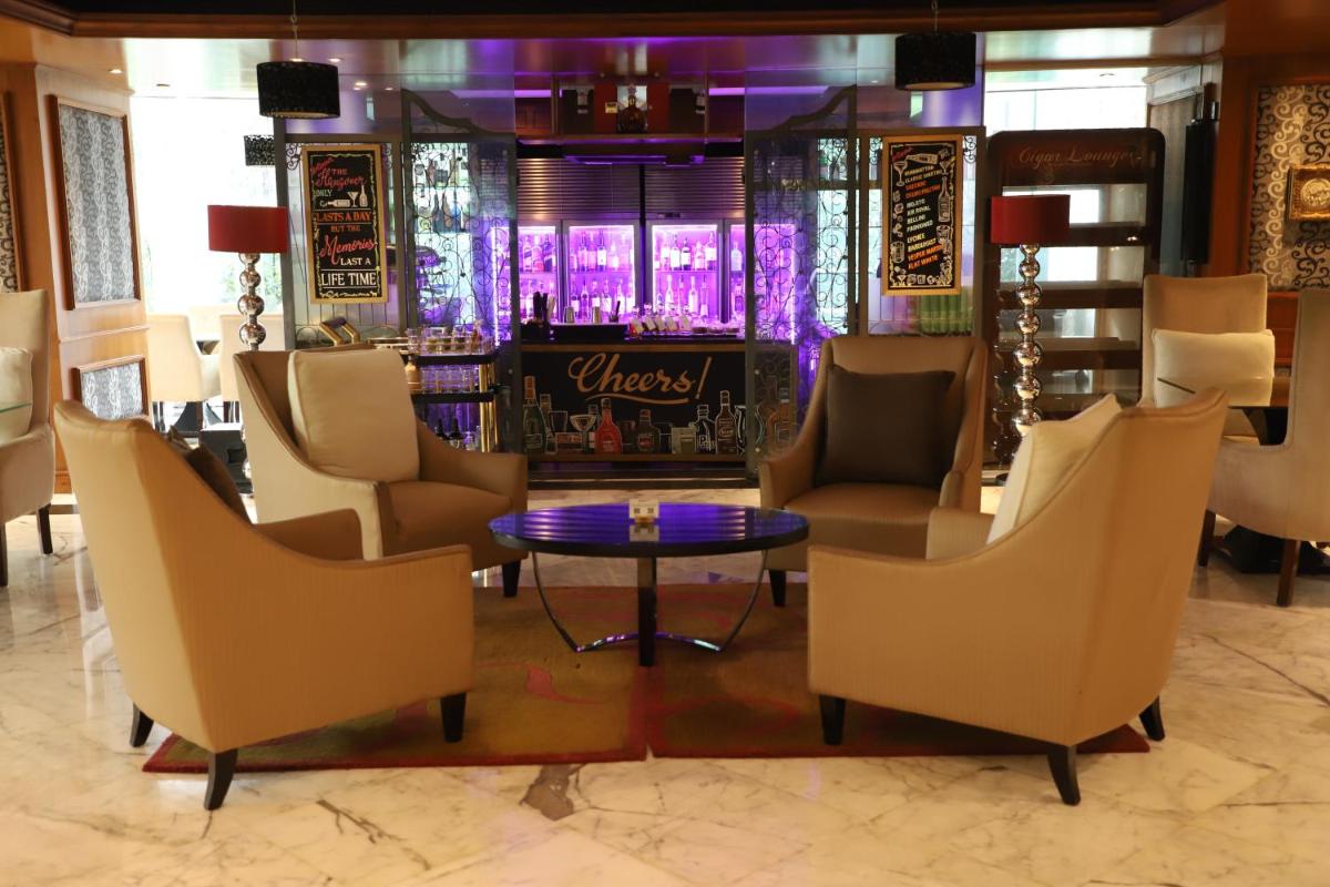 a lobby with chairs and a table and a bar at Sofitel Mumbai BKC in Mumbai