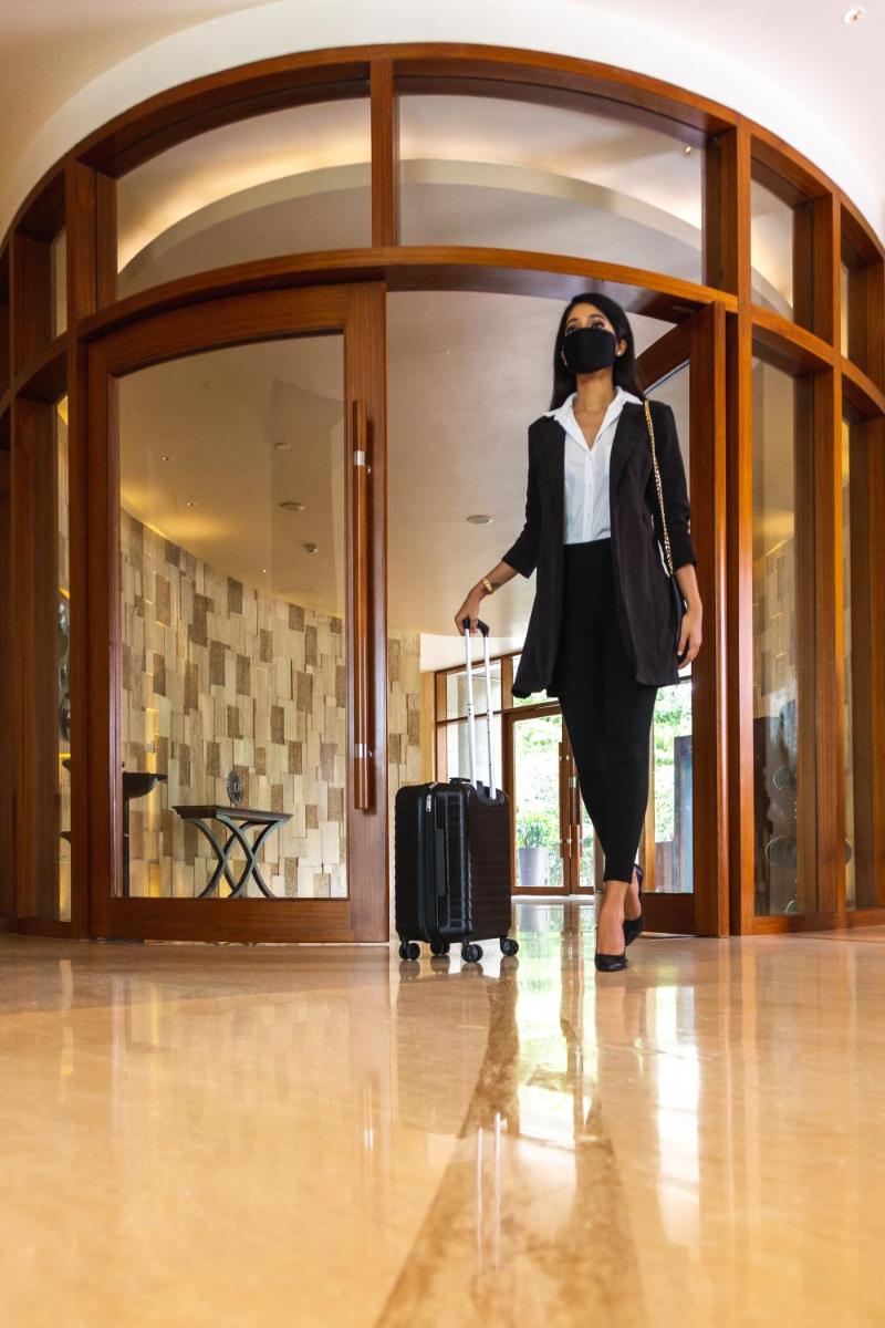 a woman walking through a building with a suitcase at Park Hyatt Chennai in Chennai