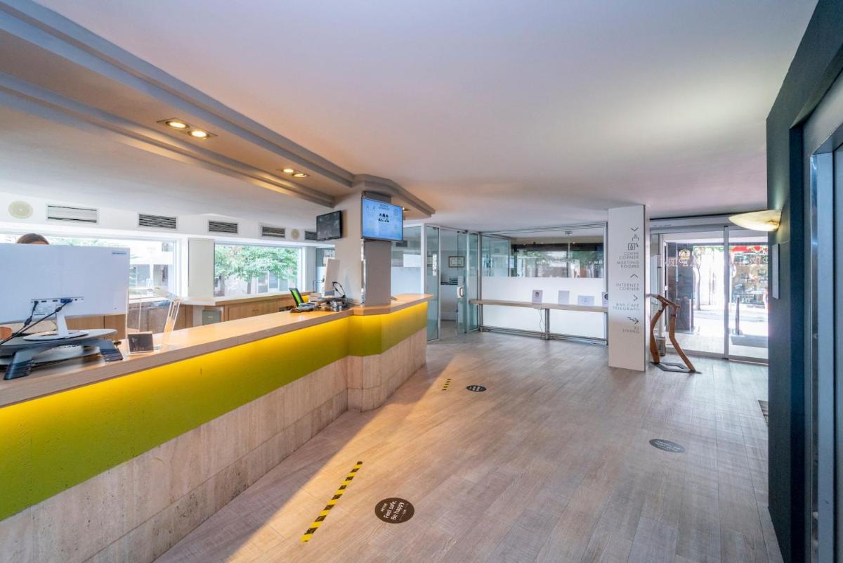 Un vestíbulo con un mostrador amarillo y verde en un edificio. en ARTIEM Capri, en Mahón 43 fotos más