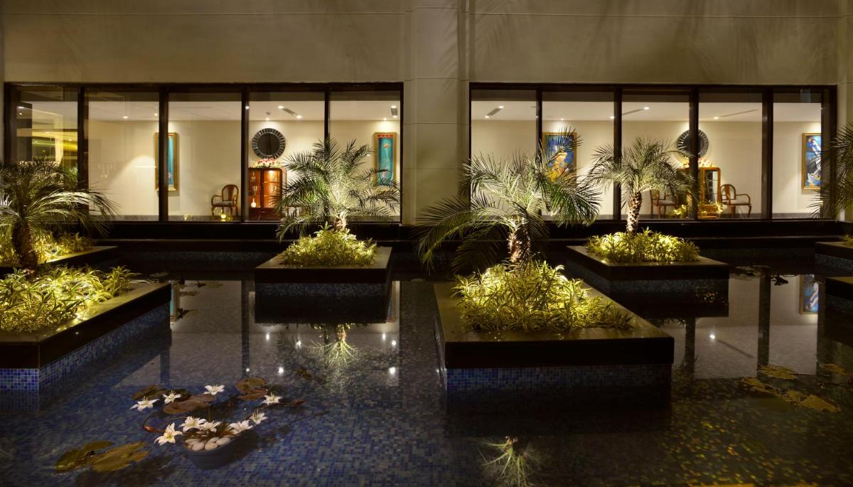 a lobby with a bunch of potted plants at The Lalit Great Eastern Kolkata in Kolkata a lobby with a bunch of potted plants at The Lalit Great Eastern Kolkata in Kolkata
