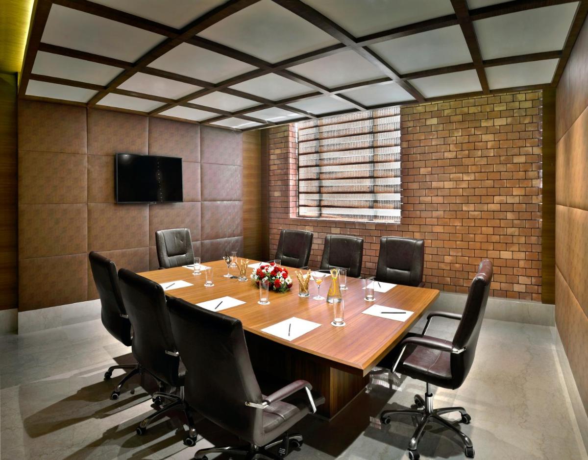 a conference room with a large wooden table and chairs at The Lalit Great Eastern Kolkata in Kolkata a conference room with a large wooden table and chairs at The Lalit Great Eastern Kolkata in Kolkata