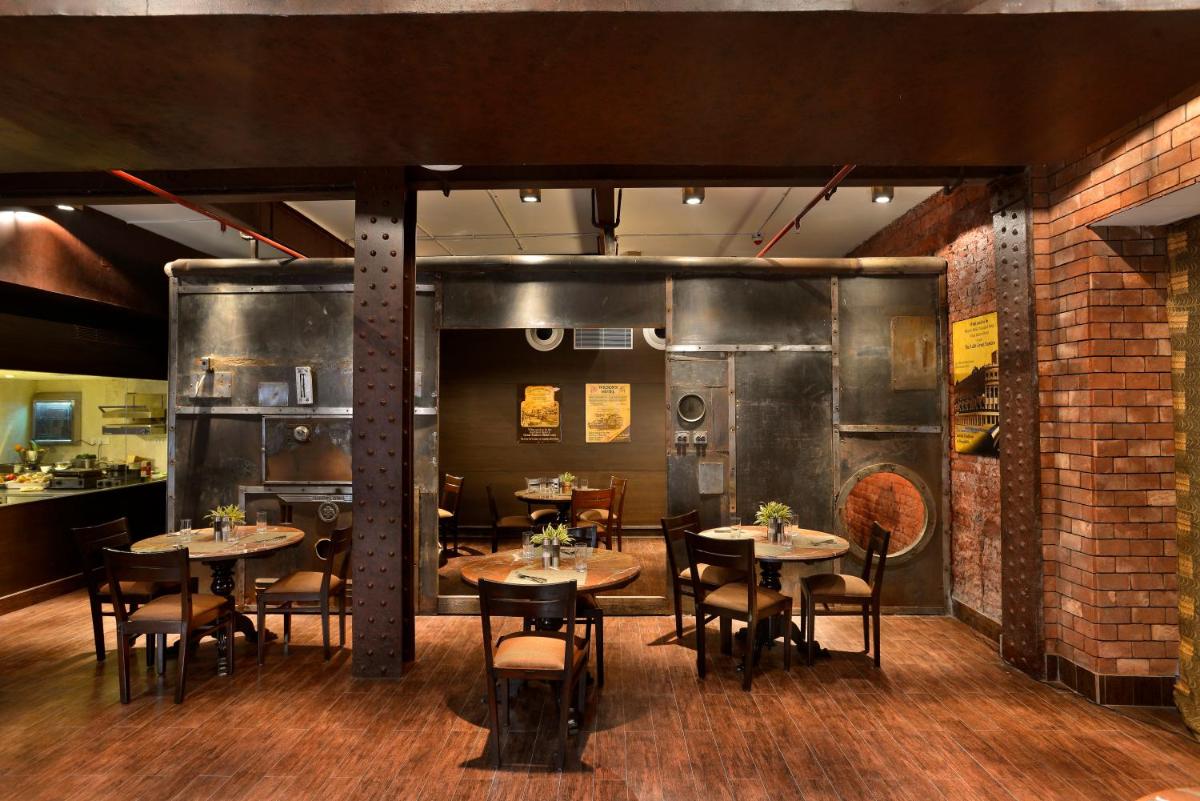 a restaurant with tables and chairs in a room at The Lalit Great Eastern Kolkata in Kolkata a restaurant with tables and chairs in a room at The Lalit Great Eastern Kolkata in Kolkata