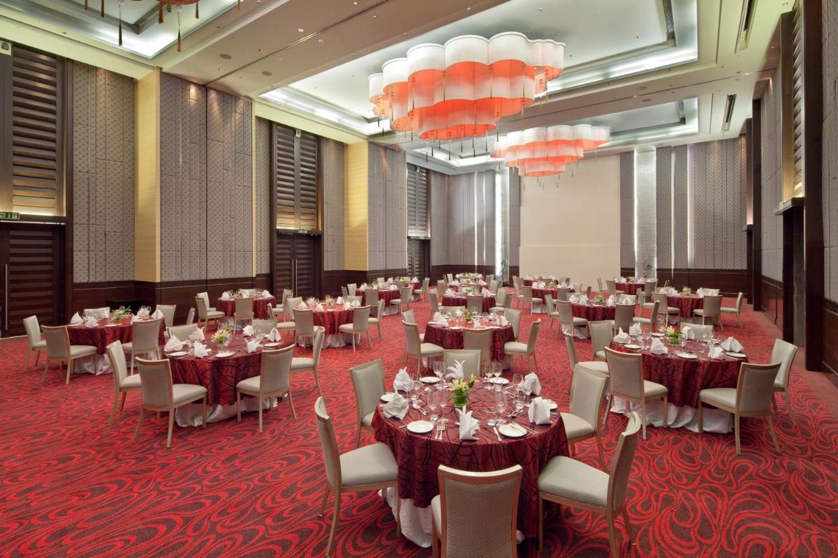 a banquet hall with tables and chairs and chandeliers at Holiday Inn Mumbai International Airport by IHG in Mumbai