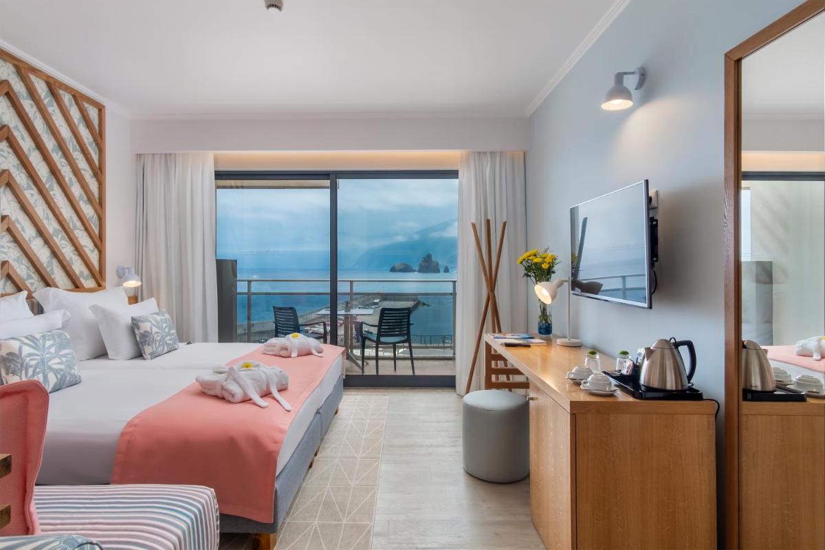 um quarto de hotel com uma cama e vista para o oceano em Aqua Natura Bay em Porto Moniz mais 65 fotografias