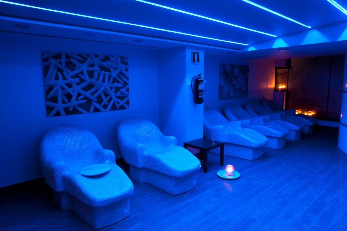 una sala de espera con luces azules y sillas azules en Hotel & Spa Real Ciudad De Zaragoza, en Zaragoza