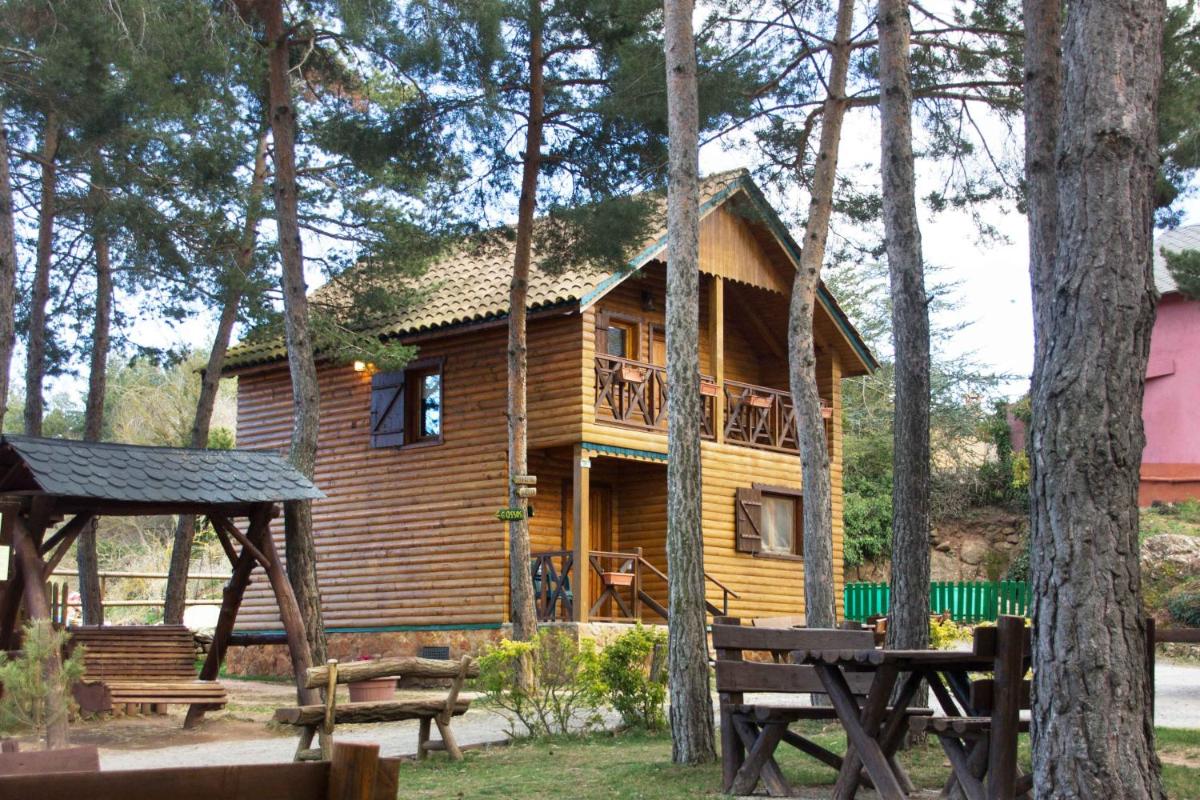 una cabaña de madera en el bosque con terraza en Xalet De Prades, en Prades