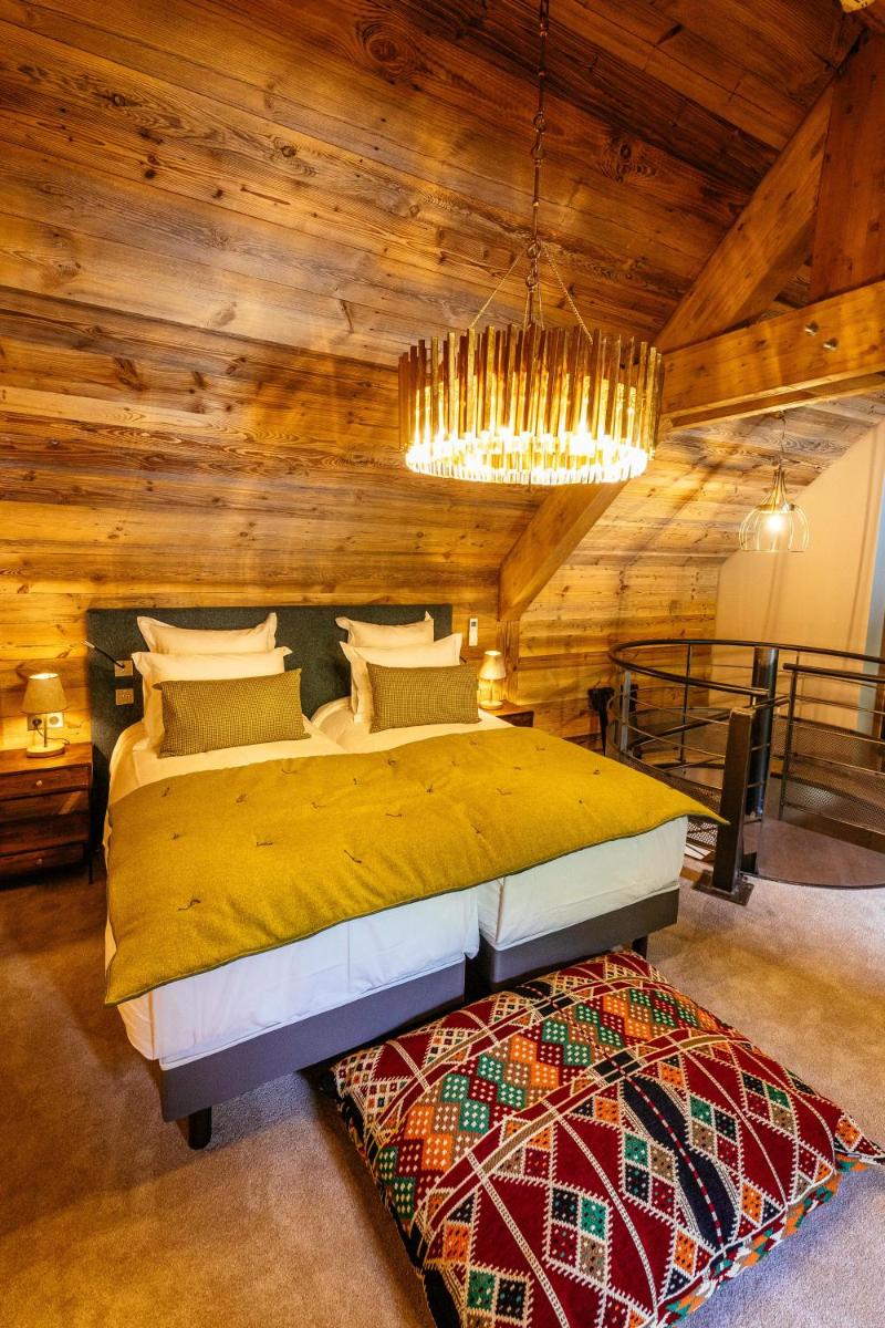 une chambre avec un lit et un lustre dans l'établissement Hotel Le V de Vaujany, à Vaujany 175 autres photos