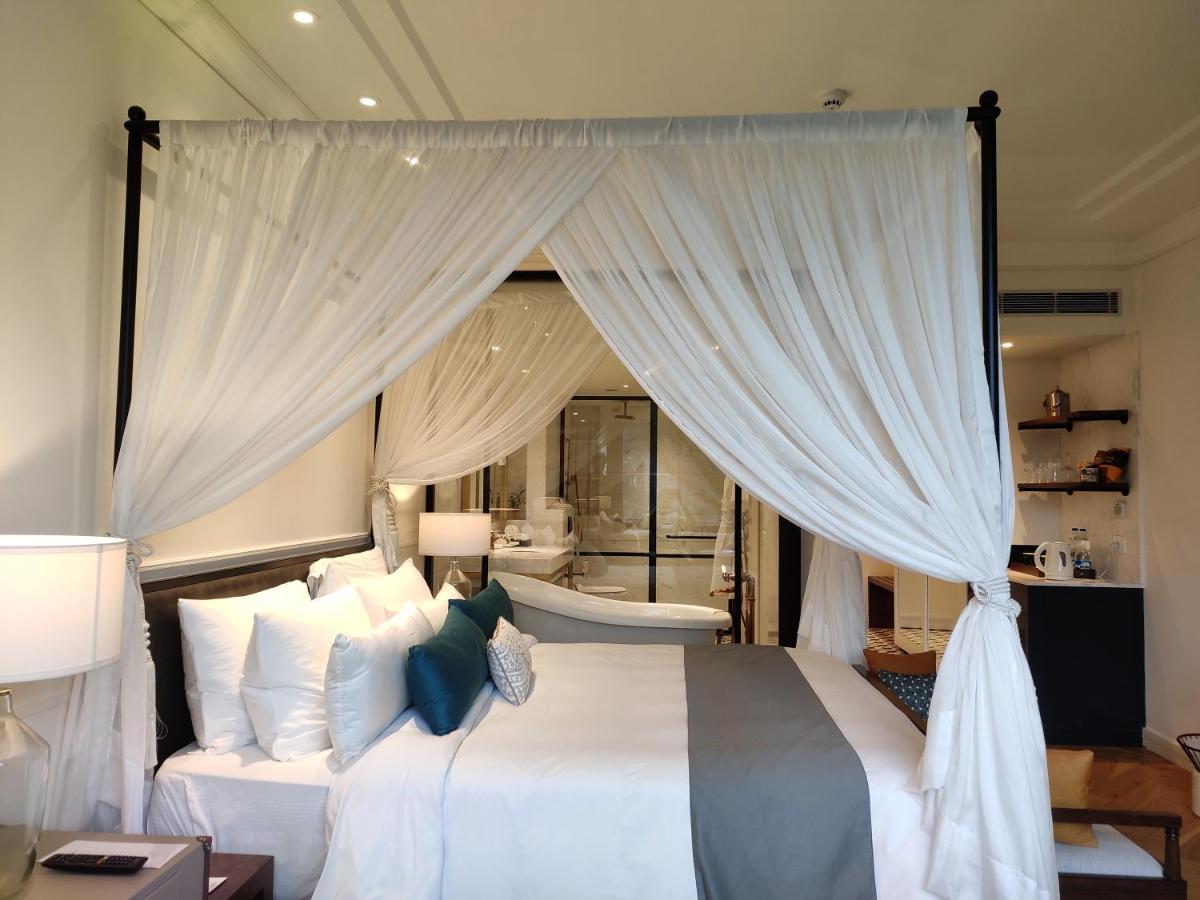 a bedroom with a large white bed with curtains at Radisson Hotel Shimla in Shimla