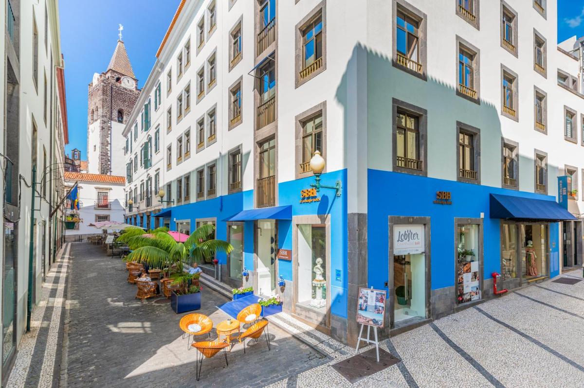 uma rua numa cidade com edifícios azuis e brancos em Sé Boutique Hotel no Funchal