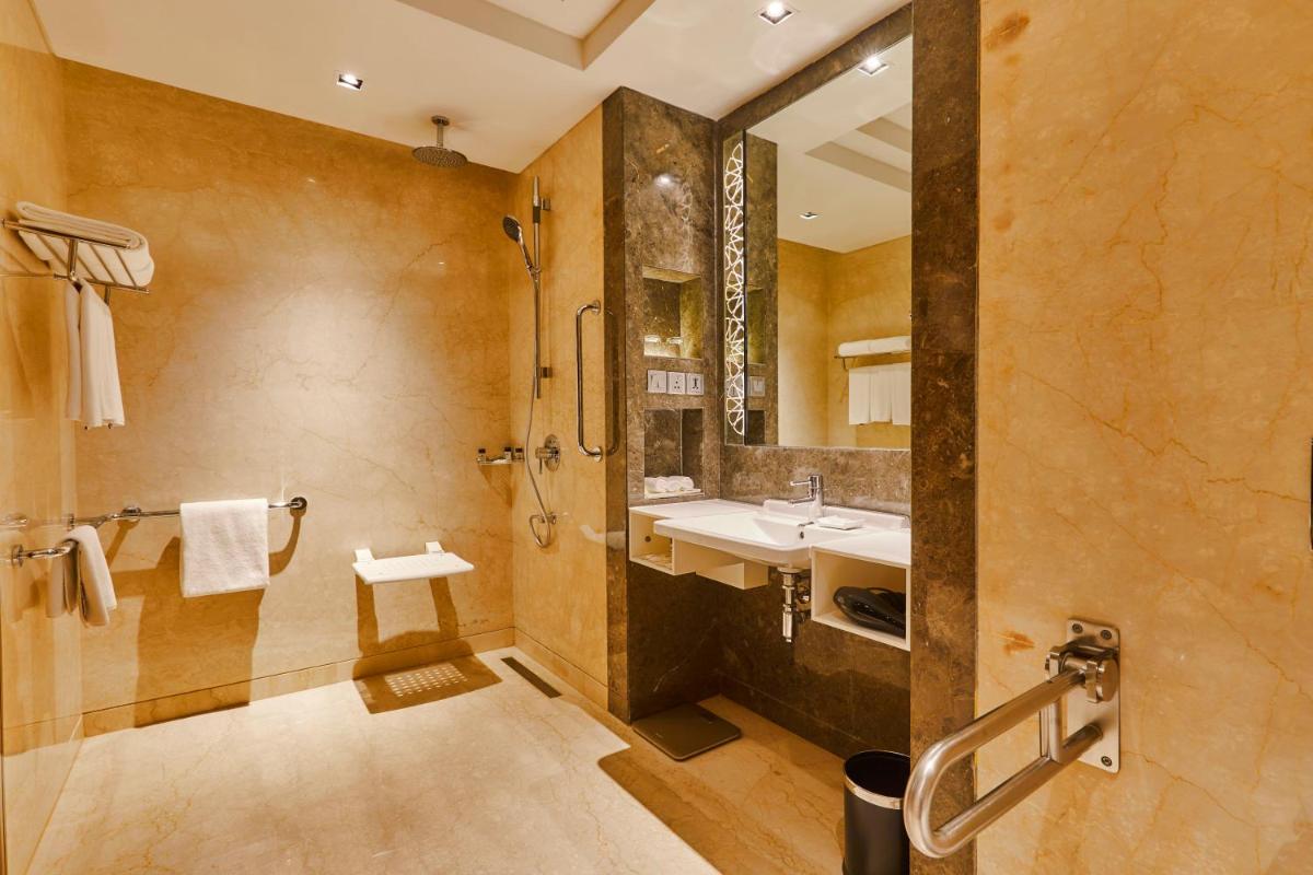 a large bathroom with a sink and a shower at Crowne Plaza New Delhi Rohini by IHG in New Delhi a large bathroom with a sink and a shower at Crowne Plaza New Delhi Rohini by IHG in New Delhi