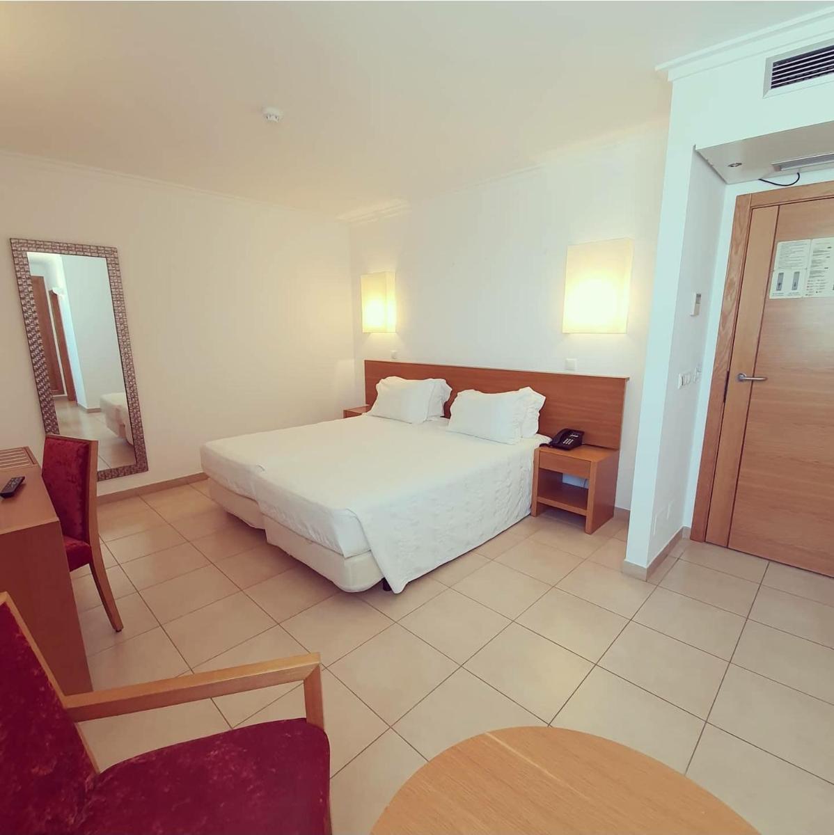 Uma cama ou camas num quarto em Monte Gordo Hotel Apartamentos & Spa