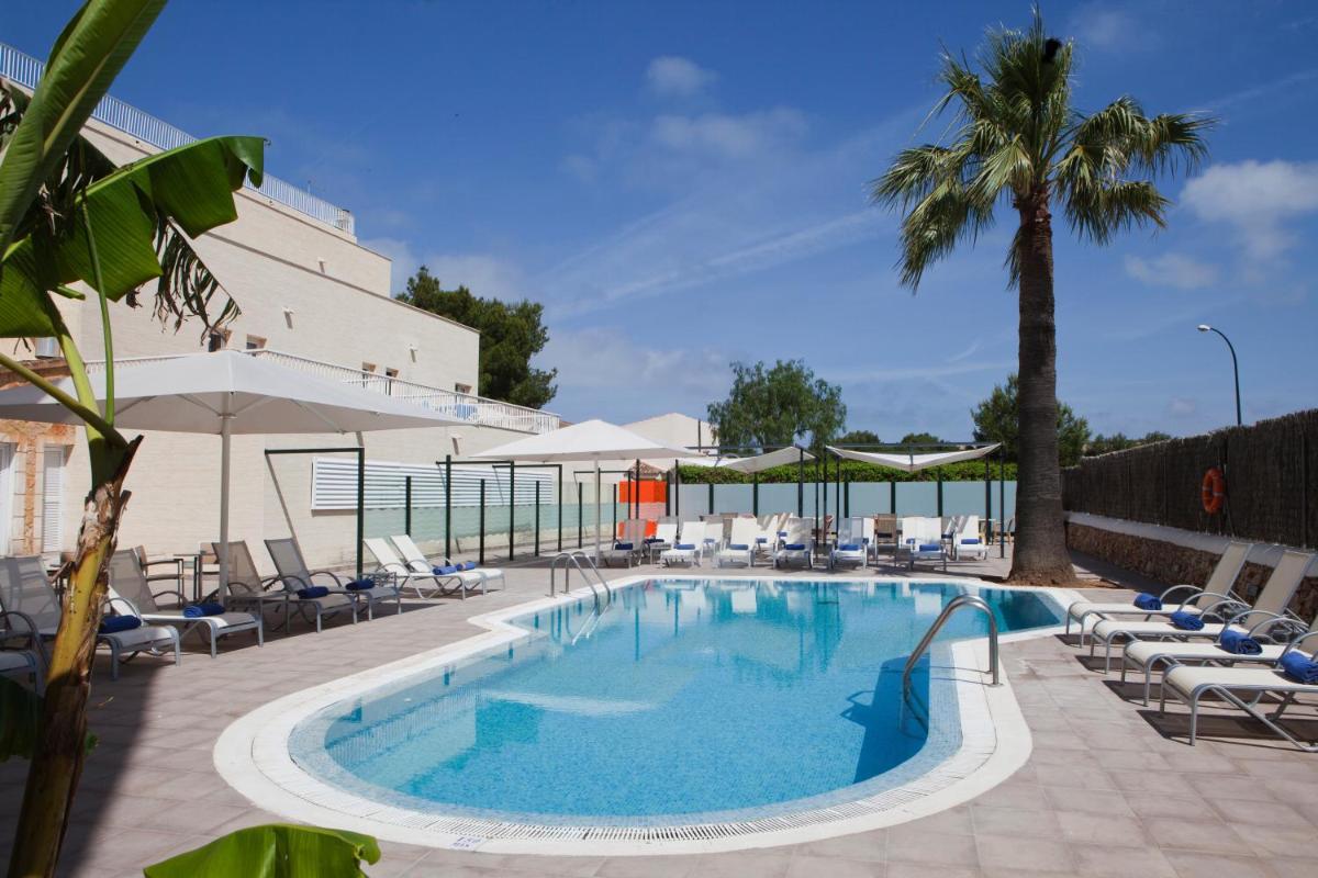 una piscina con tumbonas y una palmera en Hotel Isla de Cabrera, en Colonia de Sant Jordi