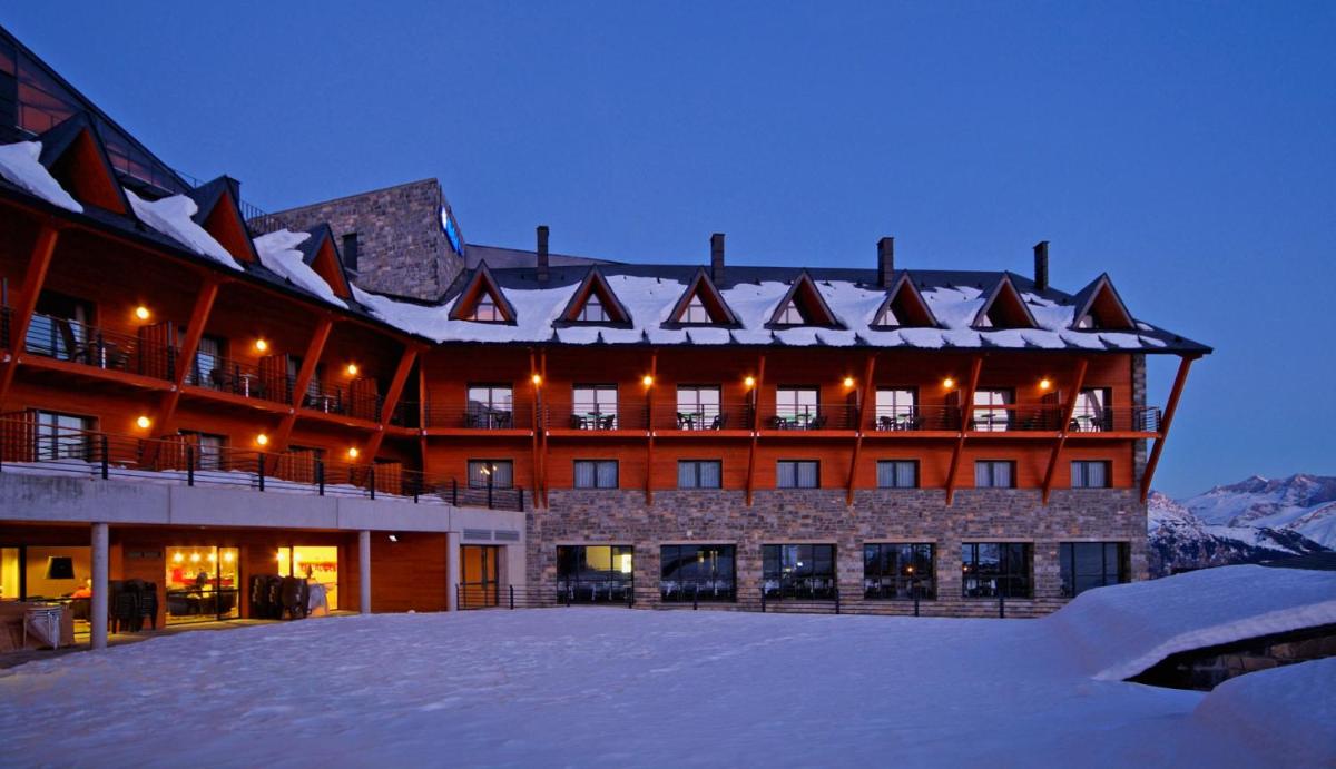 Un gran edificio con nieve delante. en HG Alto Aragón, en Formigal