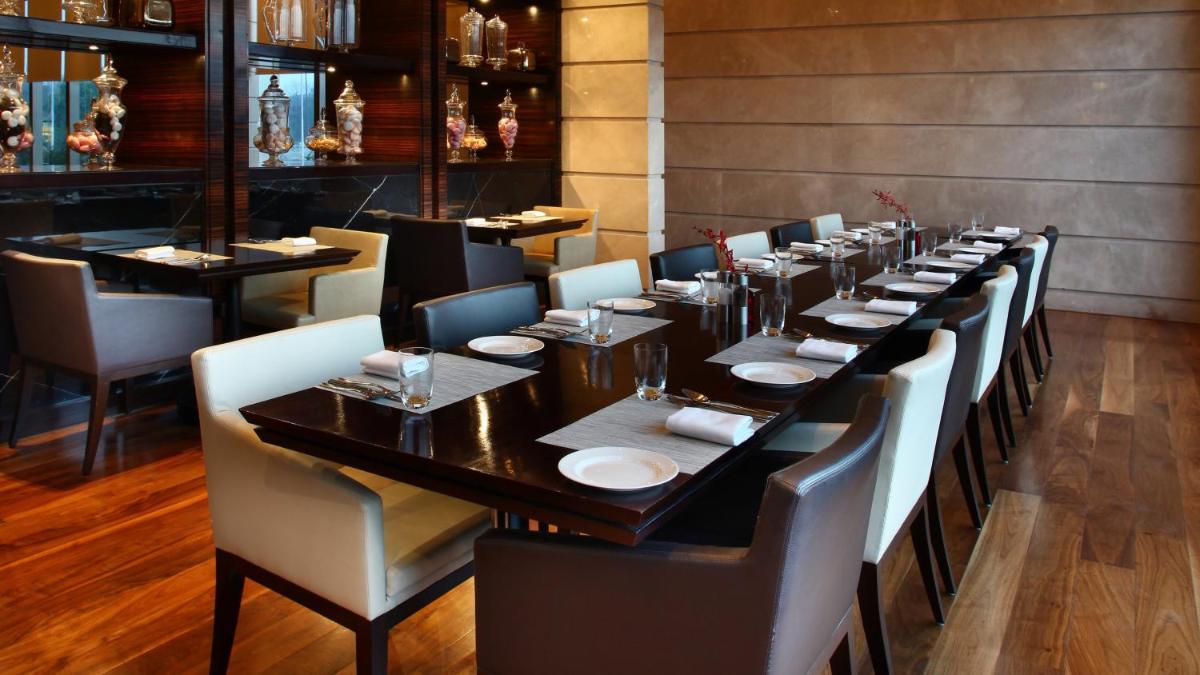 a long dining room with a long table and chairs at Crowne Plaza New Delhi Rohini by IHG in New Delhi a long dining room with a long table and chairs at Crowne Plaza New Delhi Rohini by IHG in New Delhi