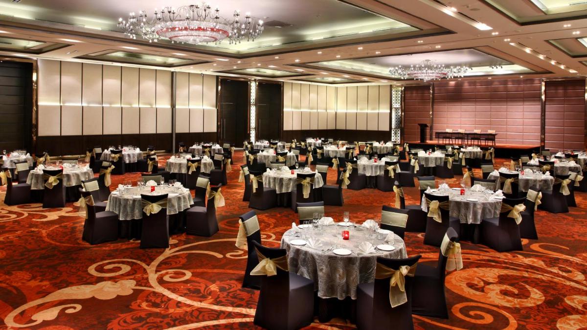 a large banquet hall with tables and chairs at Crowne Plaza New Delhi Rohini by IHG in New Delhi a large banquet hall with tables and chairs at Crowne Plaza New Delhi Rohini by IHG in New Delhi