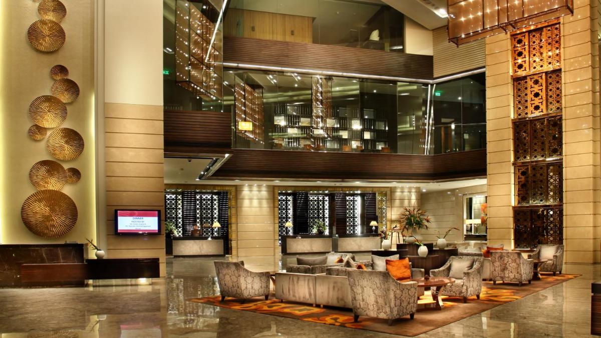 a lobby of a hotel with couches and a bar at Crowne Plaza New Delhi Rohini by IHG in New Delhi a lobby of a hotel with couches and a bar at Crowne Plaza New Delhi Rohini by IHG in New Delhi