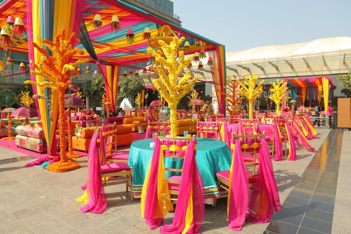 a group of tables and chairs in front of a building at Crowne Plaza New Delhi Rohini by IHG in New Delhi a group of tables and chairs in front of a building at Crowne Plaza New Delhi Rohini by IHG in New Delhi