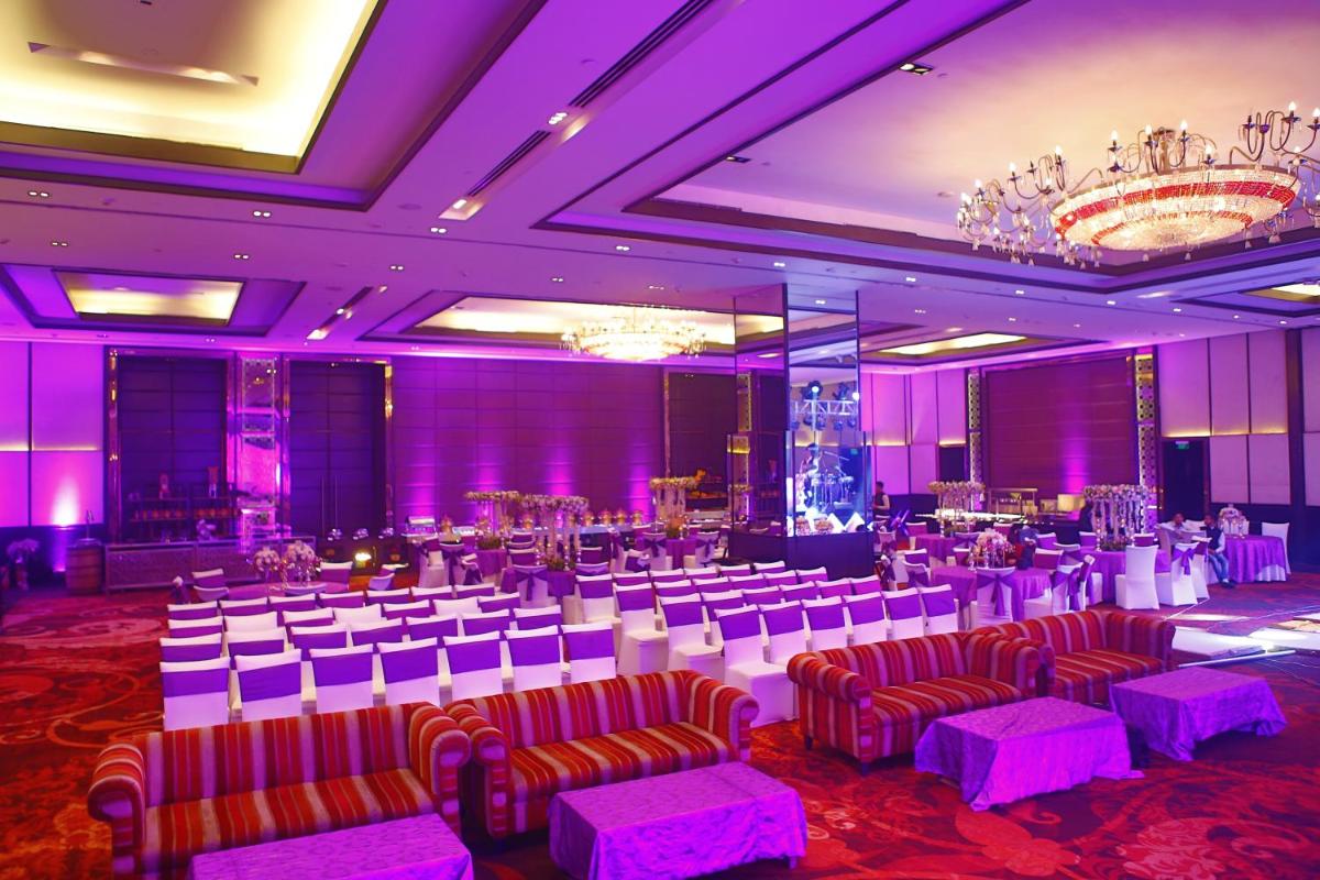 a banquet hall with tables and chairs and purple lighting at Crowne Plaza New Delhi Rohini by IHG in New Delhi a banquet hall with tables and chairs and purple lighting at Crowne Plaza New Delhi Rohini by IHG in New Delhi