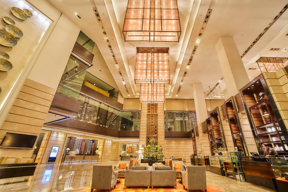 a lobby of a building with chairs and a chandelier at Crowne Plaza New Delhi Rohini by IHG in New Delhi a lobby of a building with chairs and a chandelier at Crowne Plaza New Delhi Rohini by IHG in New Delhi