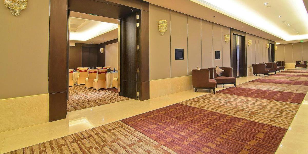 a conference room with tables and chairs and a hallway at Crowne Plaza Kochi by IHG in Cochin