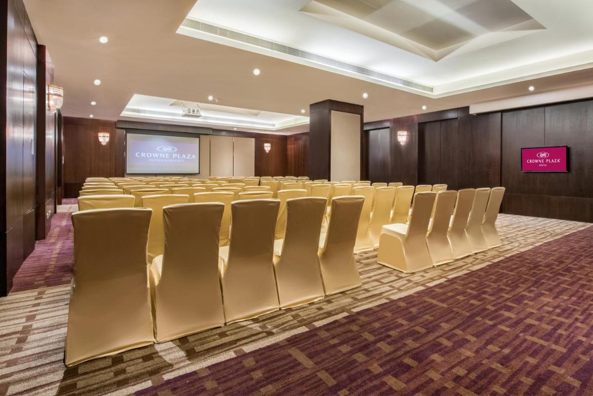 a conference room with rows of chairs and a screen at Crowne Plaza Kochi by IHG in Cochin