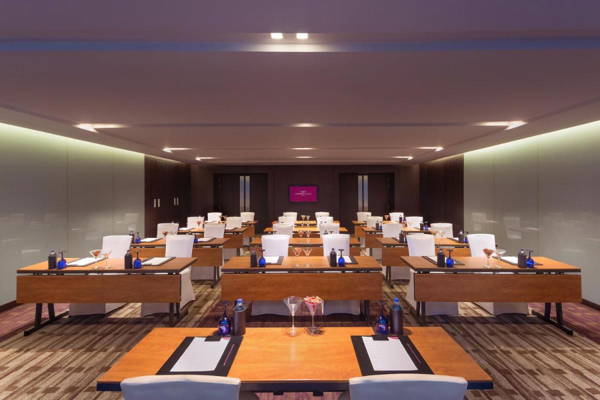 a conference room with tables and white chairs at Crowne Plaza Kochi by IHG in Cochin