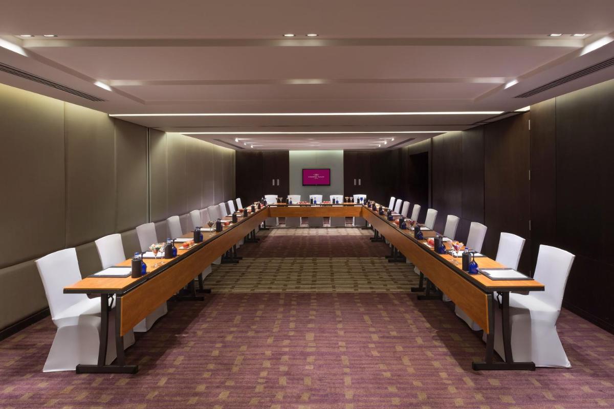 a long table in a room with white chairs at Crowne Plaza Kochi by IHG in Cochin
