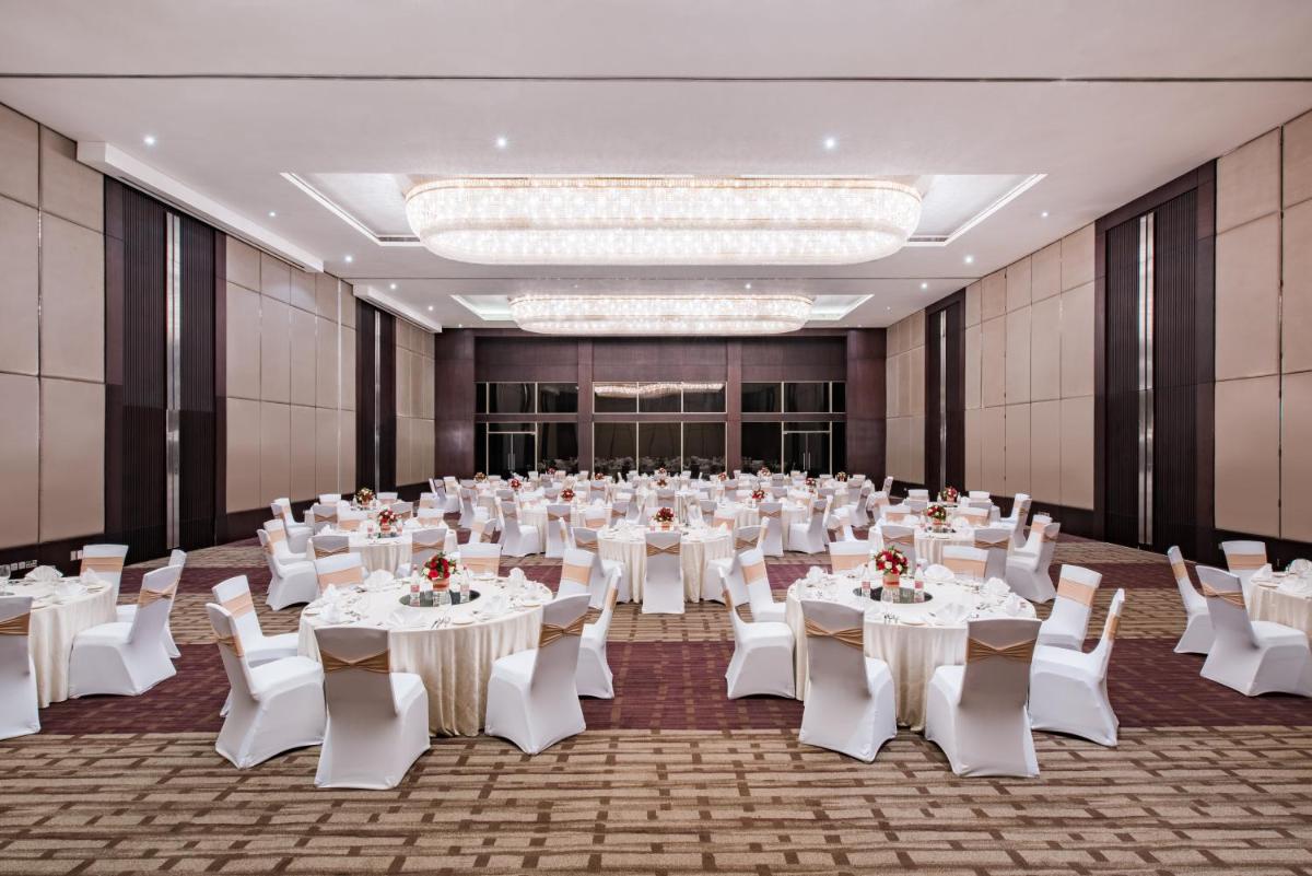 a large banquet hall with white tables and chairs at Crowne Plaza Kochi by IHG in Cochin +152 photos